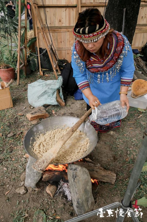 換天國爸的女兒--Ibu上場接力囉！（煮小米飯，必須全心全意地照顧，不斷翻攪、忍受高溫與煙燻......真的不是一件簡單的事）水太乾得加一點水，再繼續翻攪。