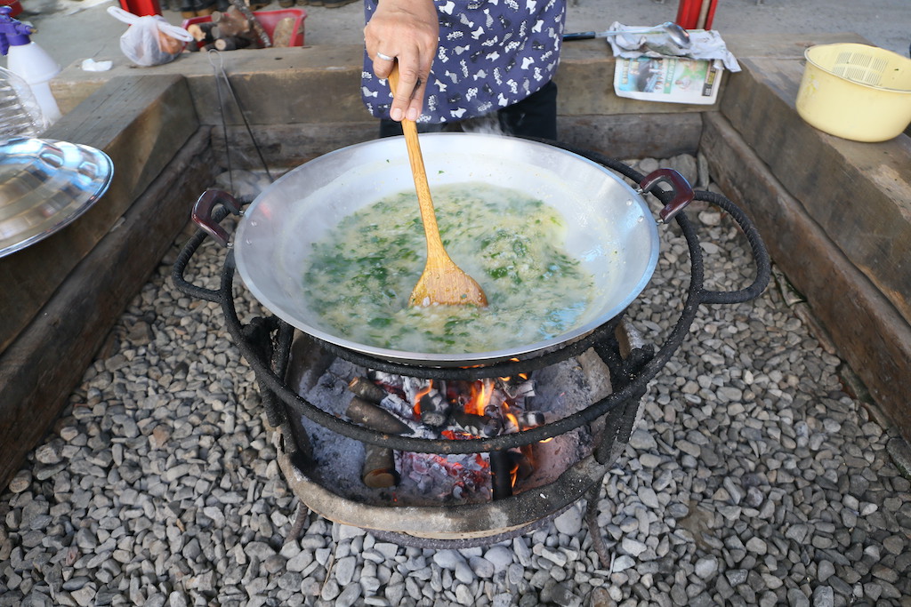 煮野菜大鍋粥的功夫，在於控制柴火，以及耐心地不斷攪拌。